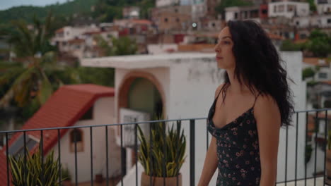 young woman on a rooftop with a tropical town in the background - focus rack from the village to the girl