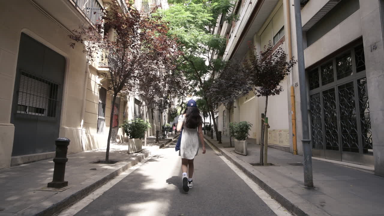 Adolescente caminhando alegremente pelas ruas estreitas do centro de Barcelona.