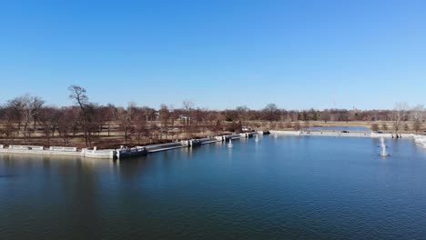 Low-aerial-flight-over-a-lake-as-a-wedding-party-gathers-on-a-cement-dock-across-the-water