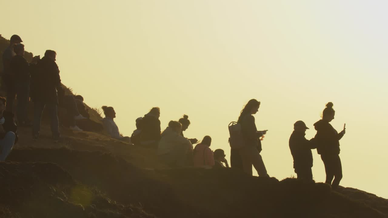 사람들은 포르투갈의 나자레 해변 가장자리에 모여 큰 파도 서퍼들이 악명 높은 오션 브레이크를 태클하는 것을 지켜봅니다.