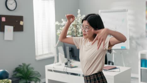 happy satisfied office worker got promotion she dances between desks in company, woman with korean beauty is cheerful, smiling, in a break from her duties she practices a new choreography