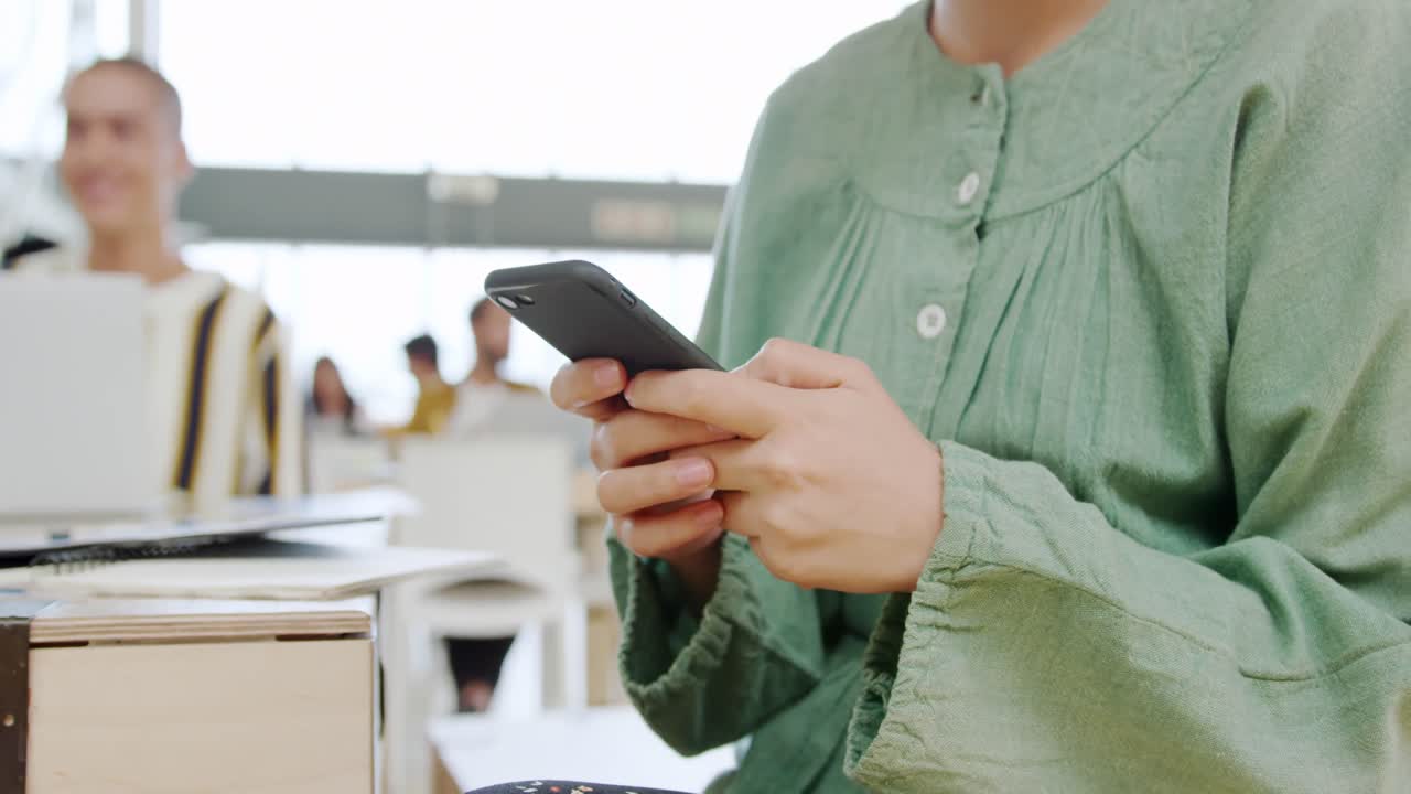 현대적인 사무실에서 스마트 폰을 사용하는 여성