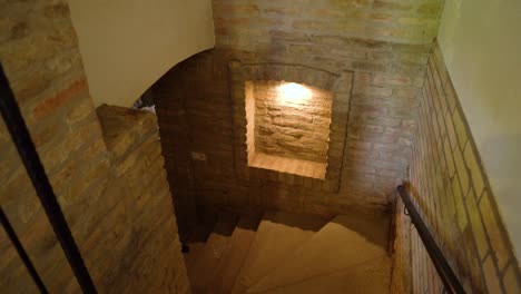 brick staircase leads down to a dimly lit wine cellar with rustic walls