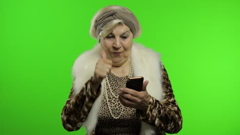 Elderly-stylish-caucasian-grandmother-woman-using-social-media-app-on-smartphone