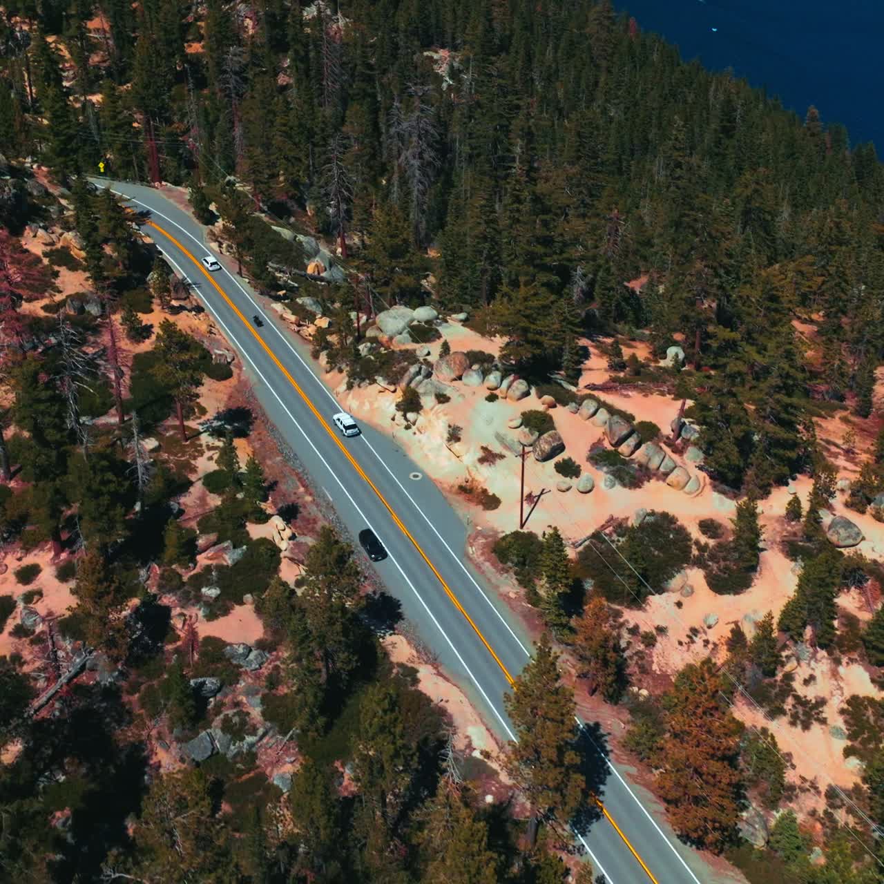 Motorway through the rocky landscape on sunny day. Roads going by the highway on the mountainous shore of Lake Tahoe