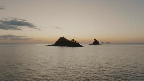 silhouette of islet in guanacaste, costa rica at sunset - aerial drone shot