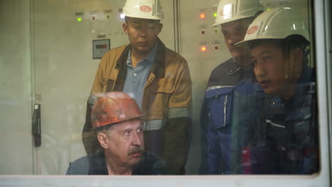 industrial workers inspecting electrical panel