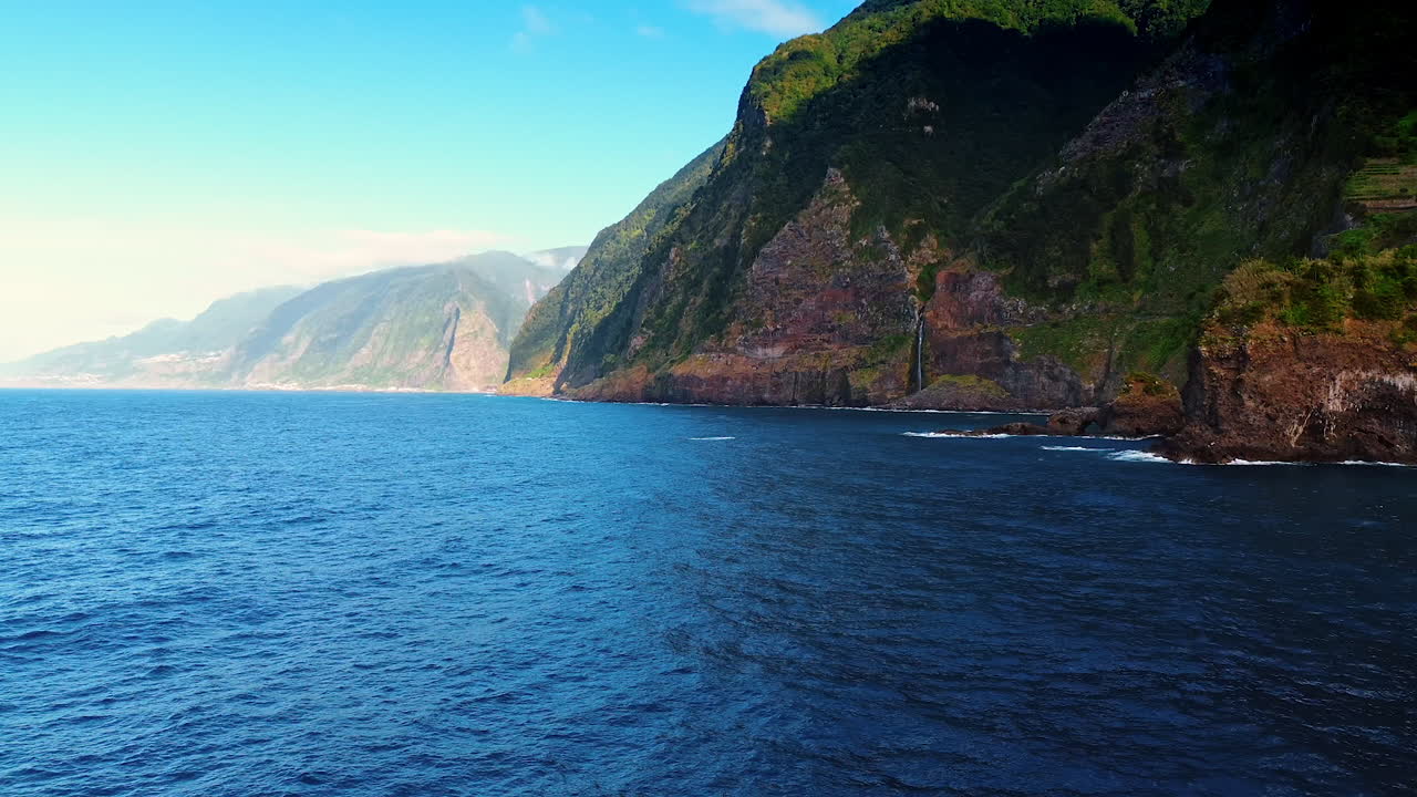 Flight over the blue waterscape of the Atlantic Ocean at the rocky shore of Madeira, Portugal.