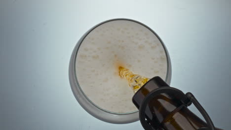 glass ice lager pouring top view. alcoholic drink filling container closeup