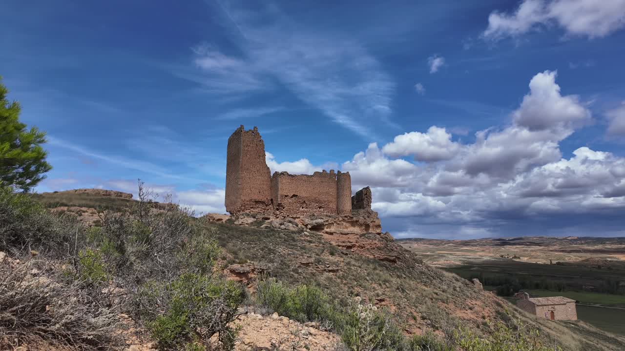 Ruined old castle standing in a barren and desolate landscape in Soria, Spain. Timelapse with a blue sky with some clouds. 4K