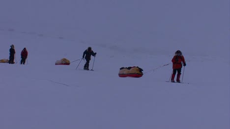 an arctic expedition moves across frozen tundra on cross country skis towing supplies 1