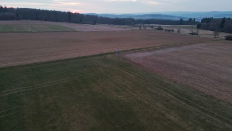 A-hunter's-tree-stand-in-the-middle-of-green-and-brown-meadows-in-Germany-during-sunset