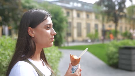 joven comiendo helado en un parque de la ciudad