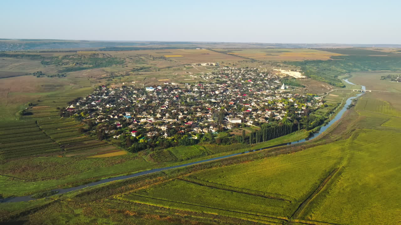 Aerial drone view of a village in Moldova. Valley with river, hills and fields in Moldova