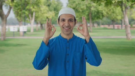 happy muslim man showing okay sign in park