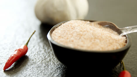 garlic, red chili pepper and salt on black background 4k