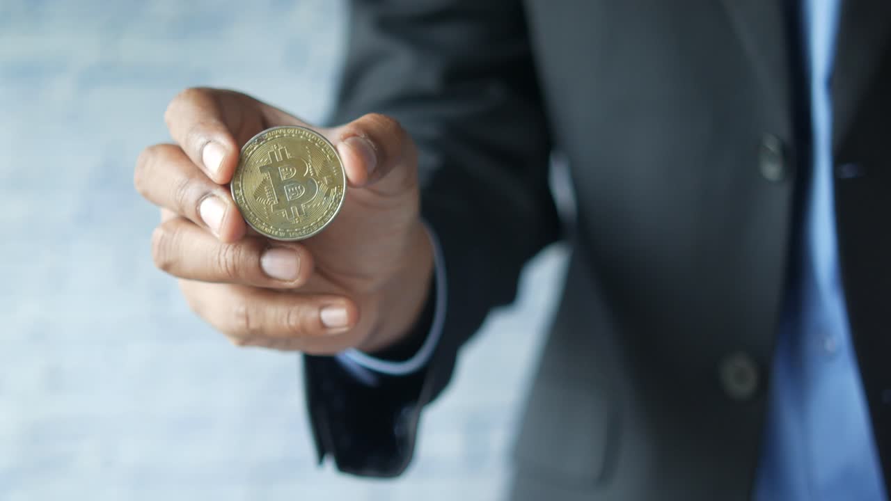 hombre sosteniendo un bitcoin