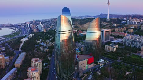 aérea - puesta de sol reflejada en las fachadas de vidrio de los rascacielos entre el hermoso paisaje urbano de baku