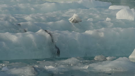 glacier lagoon, jökulsárlón, iceland, with icebergs and flowing icy blue water