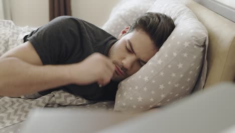 hombre cansado escuchando el ruido de los vecinos. hombre enojado tratando de dormir por la mañana.