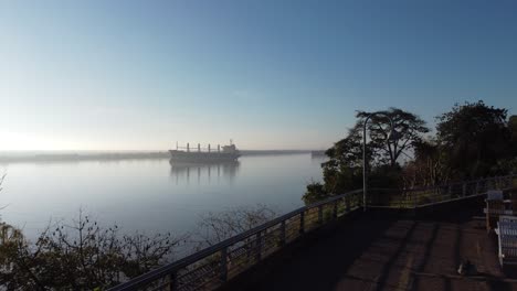 vuelo aéreo en la orilla del río paraná en rosario, argentina, con vistas a un gran barco transoceánico