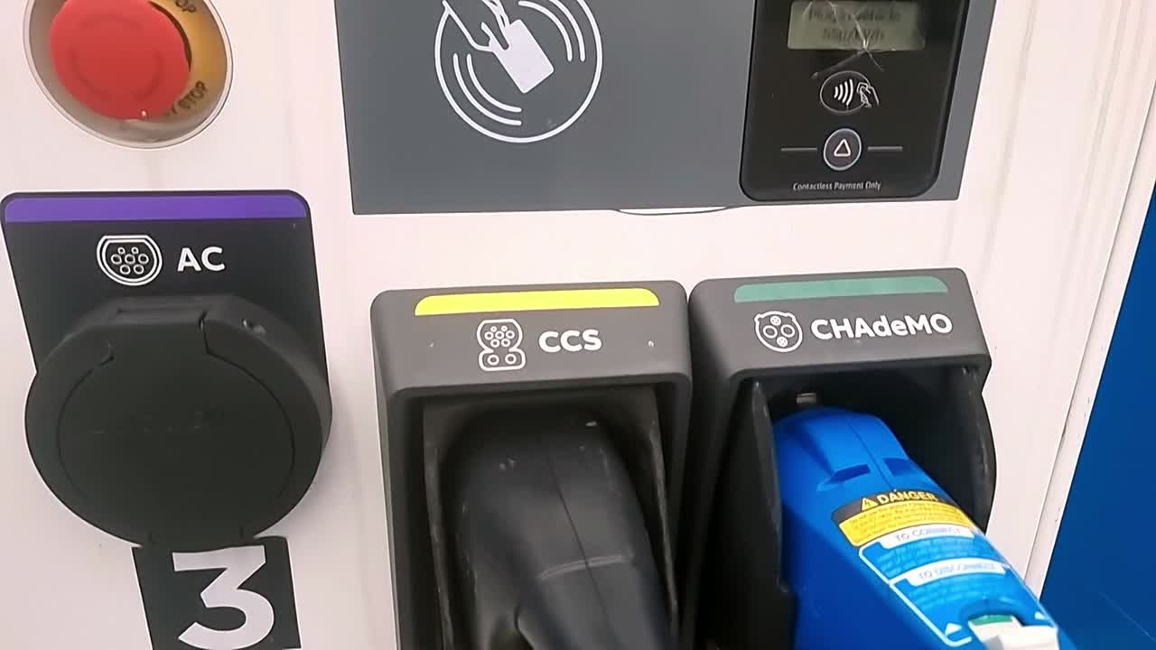 Electric vehicle power charging station energy payment screen in modern infrastructure car park