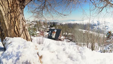 view establishing handheld from a cabin amidst a completely snow-covered landscape in the mountain village of farellones, chile