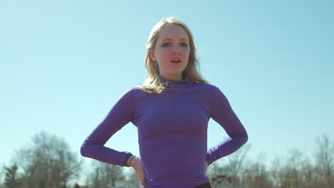 Teen-girl-on-track-walks-towards-camera-in-slow-motion-before-her-run