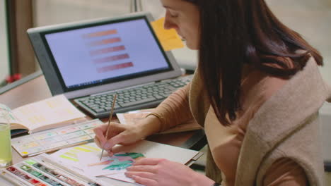 joven diseñador gráfico trabajando en una computadora de escritorio moderna mientras usa una tableta gráfica en el escritorio de la oficina.