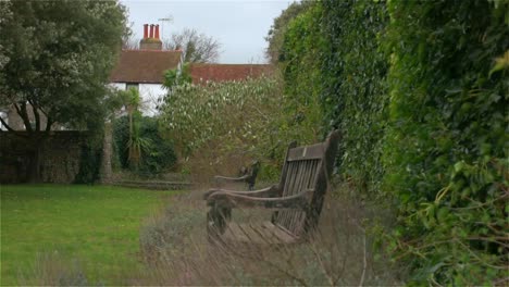 Left-tracking-of-empty-park-benches-on-a-windy-evening-in-a-classic-old-English-village