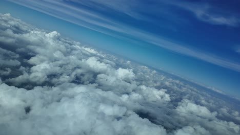piloto pov en una aguda vuelta a la izquierda sobre algunas nubes en un dramático cielo de invierno, luz del día, cielo azul profundo