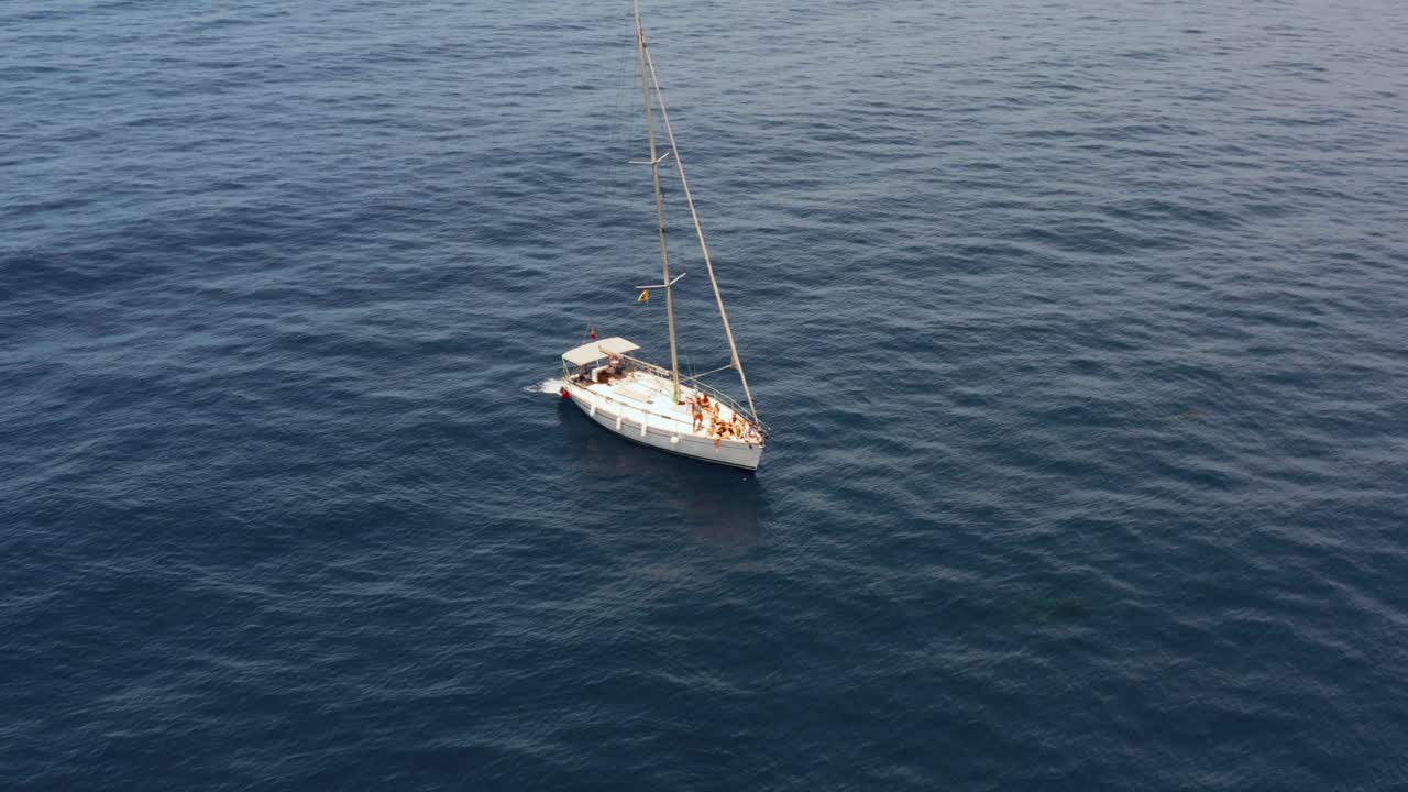 barco de vela blanco flotando en la superficie del océano azul en el atlántico, aéreo