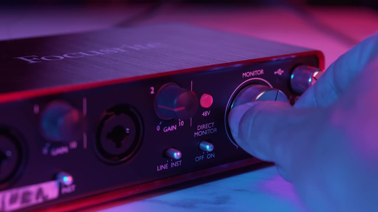 Hånd justerer volumenknap på Focusrite Audio-interface