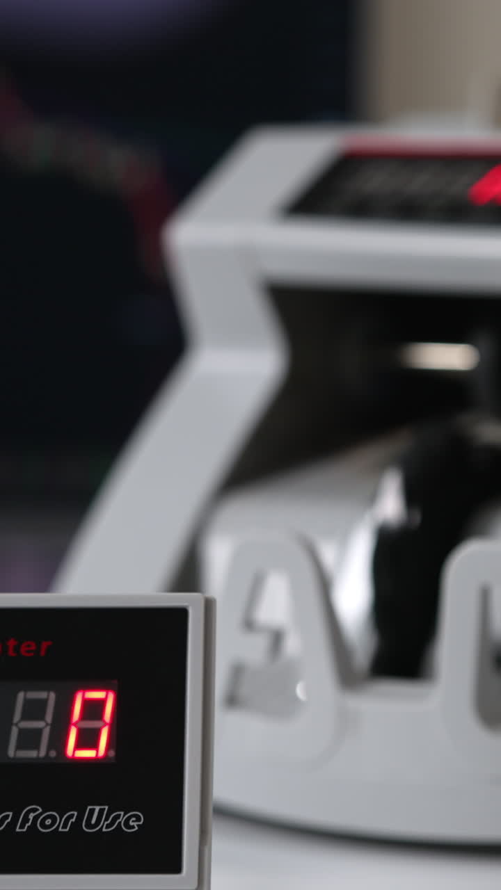 White compact money-counting machine working. Fifty euro banknotes calculated in the equipment. Close up. Blurred backdrop. Vertical video