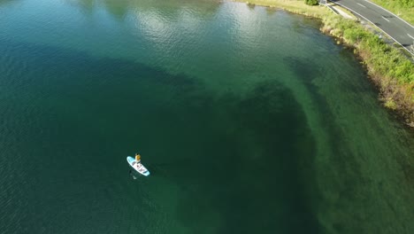blue lake tourist on paddle bord 4k drone shot in new zealand