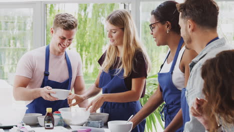 maestra con estudiante mezclando ingredientes para una receta en clase de cocina en la cocina