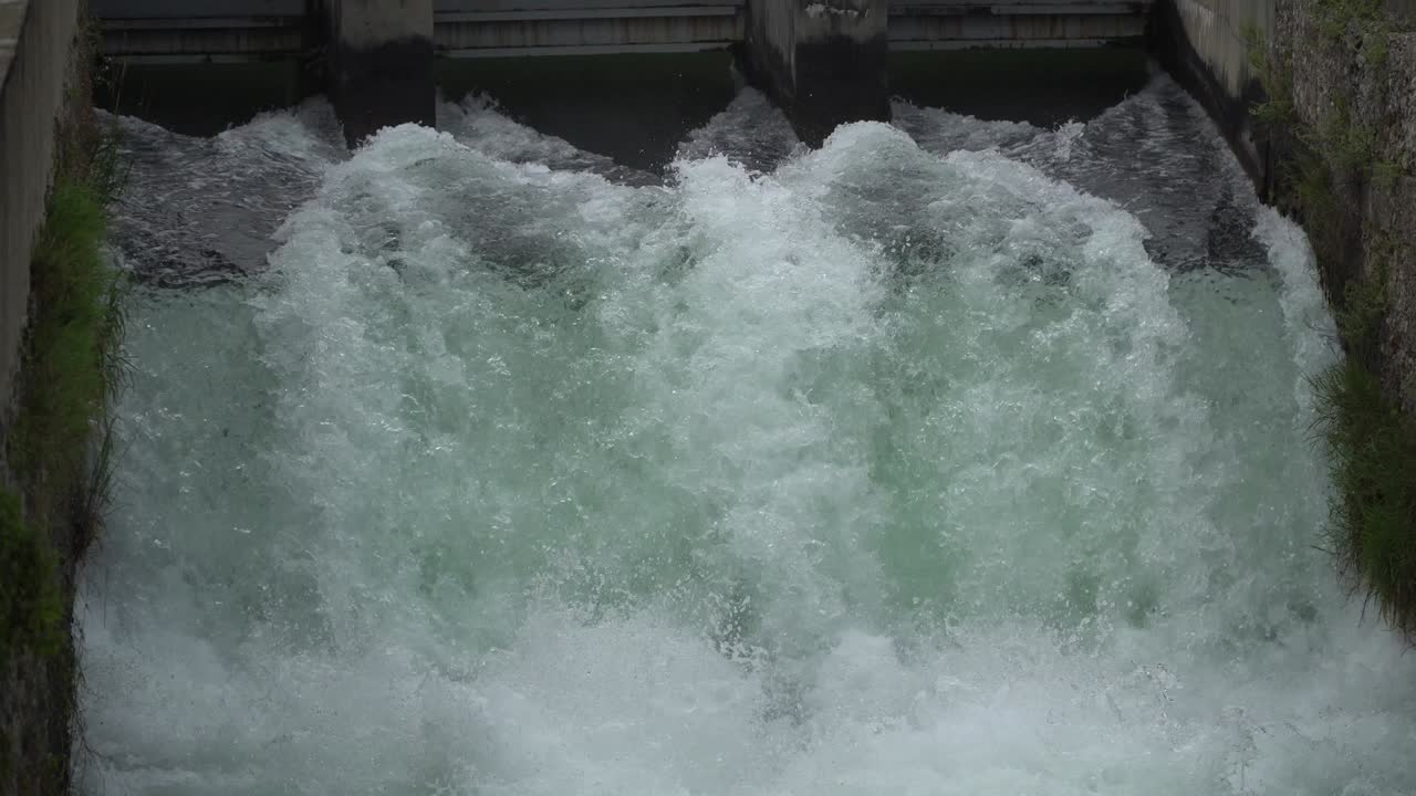 River dam - Flowing and splashing water in cold river.
