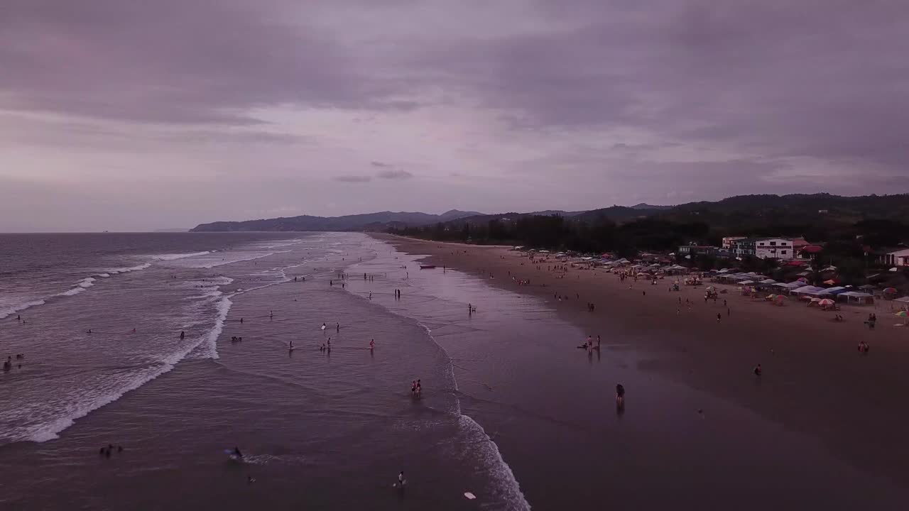 clima nublado en la playa en olón, ecuador - gente nadando y relajándose - drone aéreo