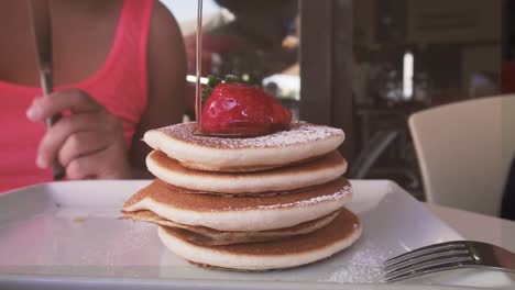 stack of pancakes with strawberry and honey