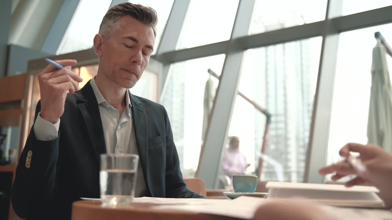 A Man Takes Notes In His Notebook In A Coffee Shop 1