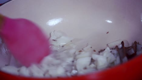 cebollas salteadas en una olla de hierro fundido para preparar la papaya verde y madura amarilla orgánica fresca