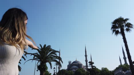 slow motion:beautiful young girl waves turkish flag with view of sultan ahmed or blue mosque in i̇stanbul,turkey,travel concept