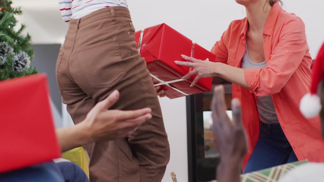 다양한 친구 들 의 행복 한 그룹 이 크리스마스 선물 을 열고 있다