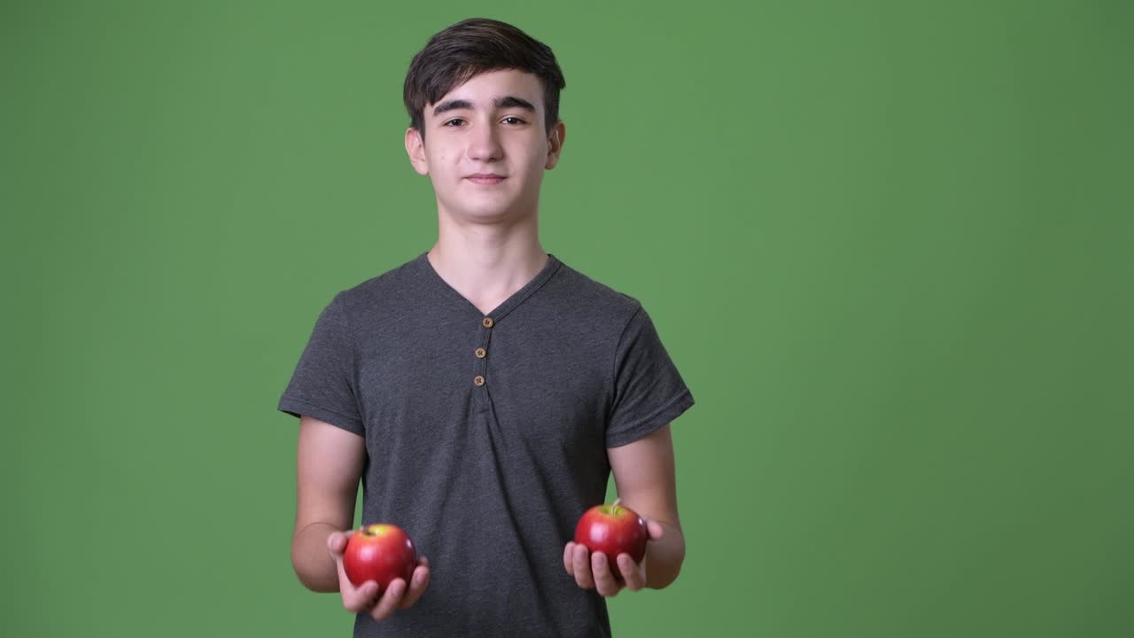 초록색 배경에 젊은 잘생긴 이란 십대 소년