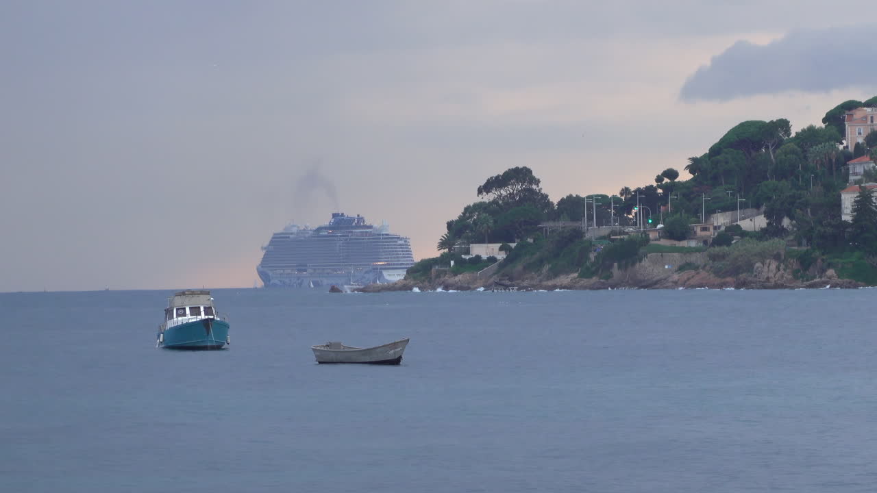 Boats moving on the sea with buildings and trees on the background
