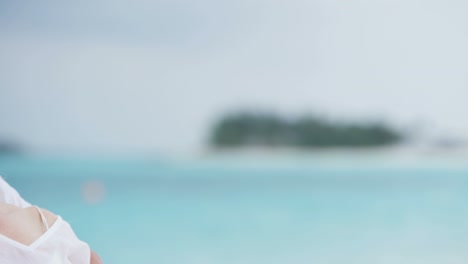 una pareja caucásica senior compartiendo un beso en una playa tropical.