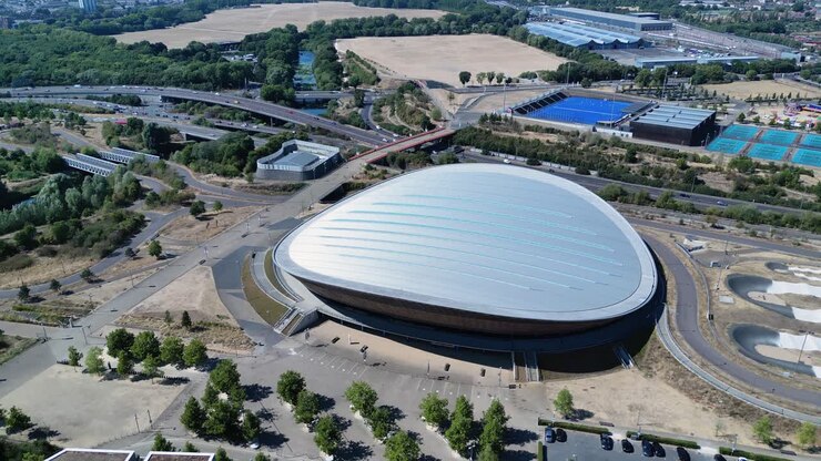 Futuristic London aquatics centre and landscaped garden, Stratford landmark attraction aerial orbiting view