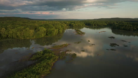 Sunset-Sky-Reflecting-On-Tranquil-Waters-Of-Lake-Sequoyah-In-AR,-USA---drone-shot