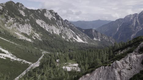 Drone-video-with-descriptive-frontal-shot-over-the-Vrsc-pass-in-Slovenia-with-mountains-on-the-horizon