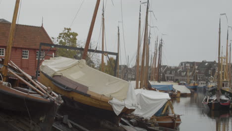 tilt down of old dutch botter boat in maintenance dock in canal running through small fishing village in the netherlands